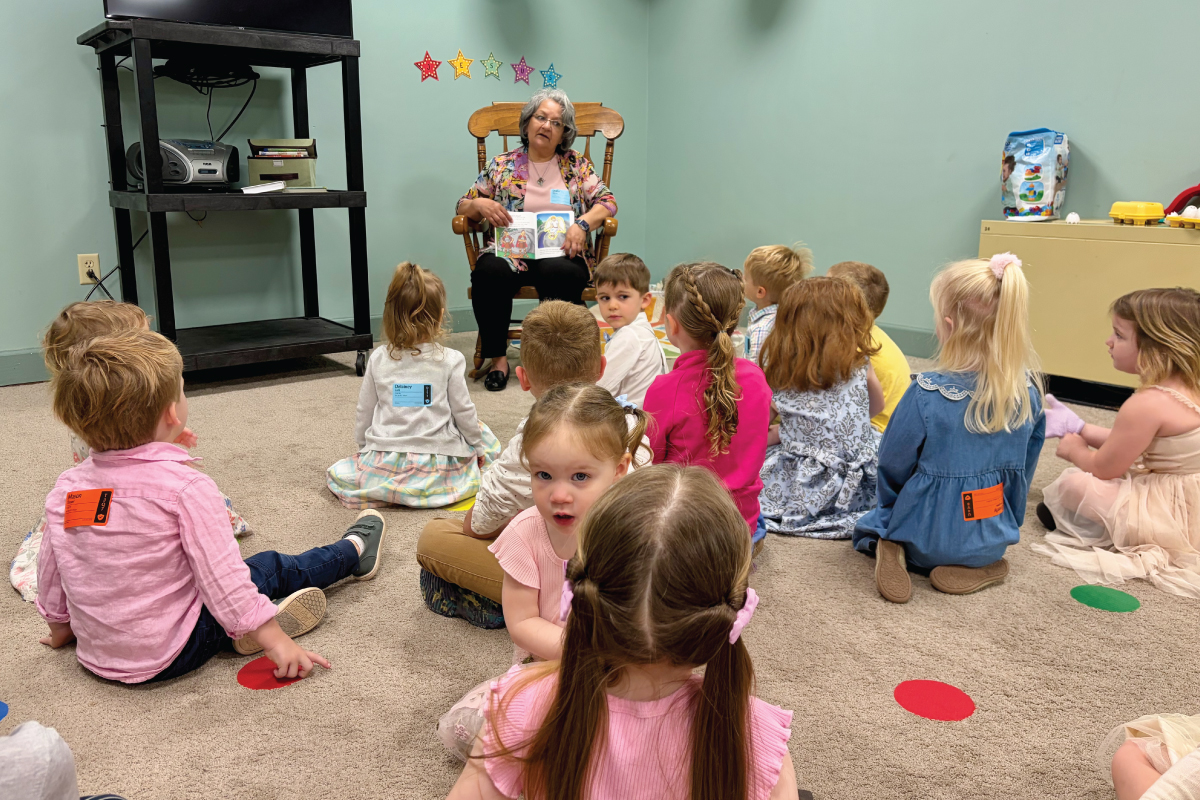 A volunteer reading a story to children during Sunday School